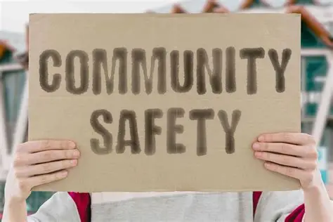 Person holding a cardboard sign with the words ‘COMMUNITY SAFETY’ written in large letters